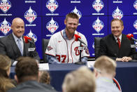 Washington Nationals pitcher Stephen Strasburg, center, smiles during a baseball media availability, accompanied by general manager Mike Rizzo, left, and agent Scott Boras, right, at Nationals Park, Tuesday, Dec. 17, 2019, in Washington. (AP Photo/Alex Brandon)