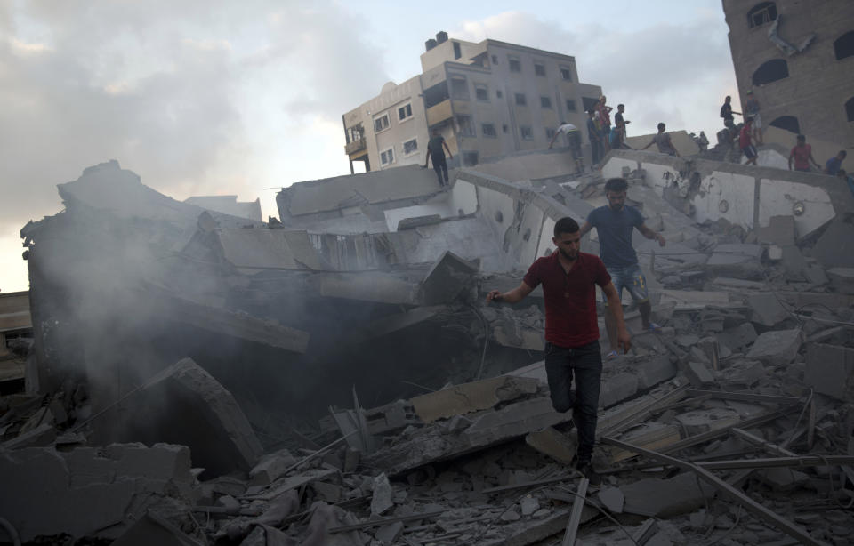 Palestinians inspect the damaged building of Said al-Mis'hal cultural center after it was hit bombed by an Israeli airstrike in Gaza City, Thursday, Aug. 9, 2018. The Palestinian Health Ministry says several bystanders were wounded in Thursday evening's airstrike in the Shati refugee camp. (AP Photo/Khalil Hamra)