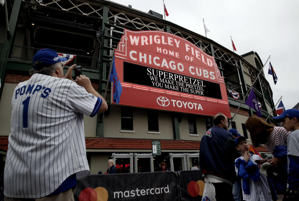 Chicago Cubs fans wait outside Wrigley Field before the National League wild-card playoff baseball game between the Colorado Rockies and the Chicago Cubs, Tuesday, Oct. 2, 2018, in Chicago. (AP Photo/Nam Y. Huh)