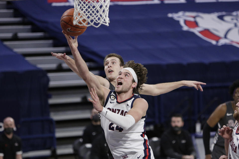 FILE - Gonzaga forward Corey Kispert, front, shoots in front of Santa Clara forward Josip Vrankic during the second half of an NCAA college basketball game in Spokane, Wash., in this Thursday, Feb. 25, 2021, file photo. Kispert has made The Associated Press All-America first team, announced Tuesday, March 16, 2021.(AP Photo/Young Kwak, File)