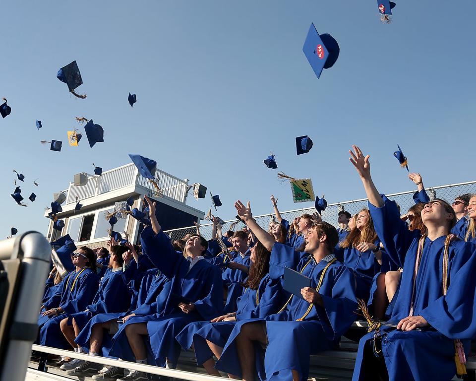 Graduating seniors toss their caps in the air during Norwell High’s graduation at the school Saturday, June 4, 2022.