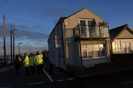 Police speak to a resident in the village of Jaywick which is threatened by a storm surge, in Essex, Britain January 13, 2017. REUTERS/Stefan Wermuth