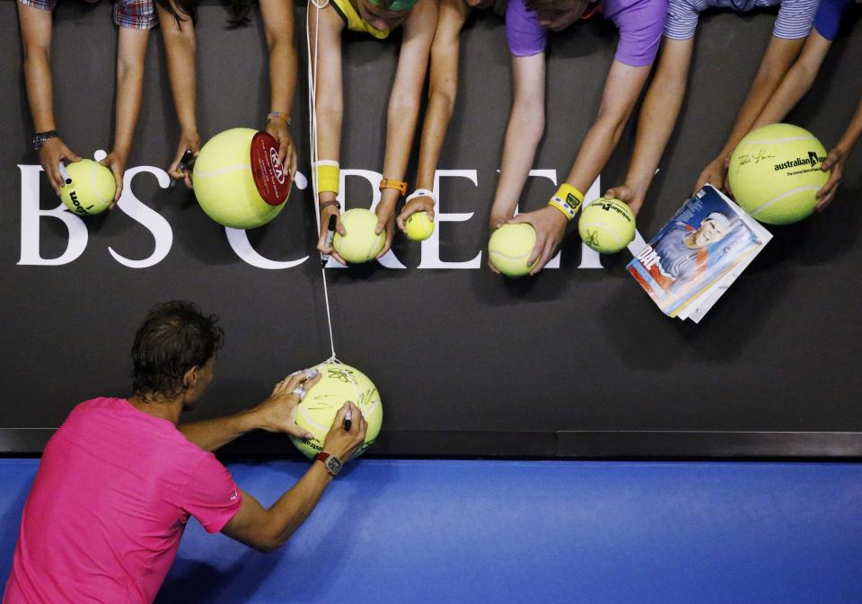 Rafael Nadal of Spain signs autographs after defeating Tim Smyczek of the U.S. in their men's singles second round match at the Australian Open 2015 tennis tournament in Melbourne January 21, 2015. REUTERS/Thomas Peter (AUSTRALIA - Tags: SPORT TENNIS)