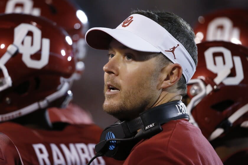 Oklahoma head coach Lincoln Riley talks with players