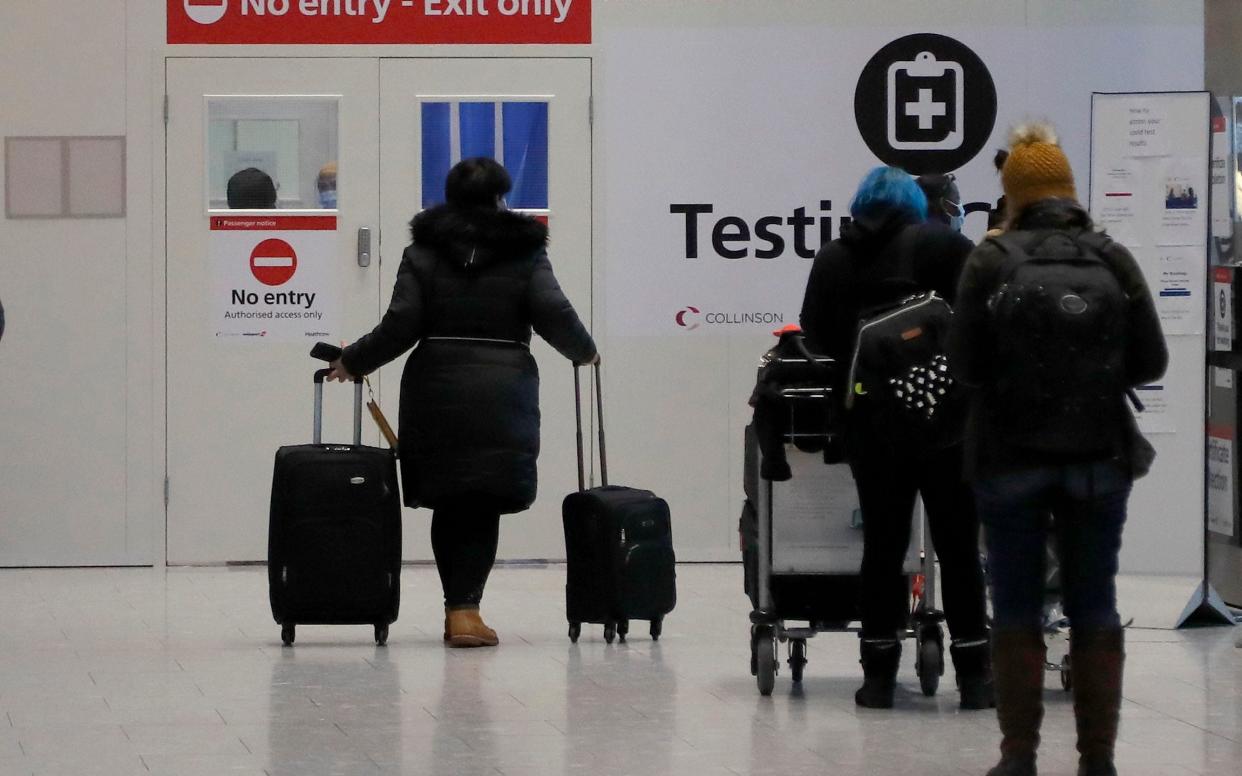 Travellers wait at the Covid-19 testing facility at Heathrow Airport in London - Frank Augstein/AP