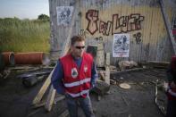 A striking French labour union employee stands near a barricade to block the entrance of the depot of the SFDM company near the oil refinery to protest the the governments proposed labor law reforms in Donges, France, May 26, 2016. REUTERS/Stephane Mahe