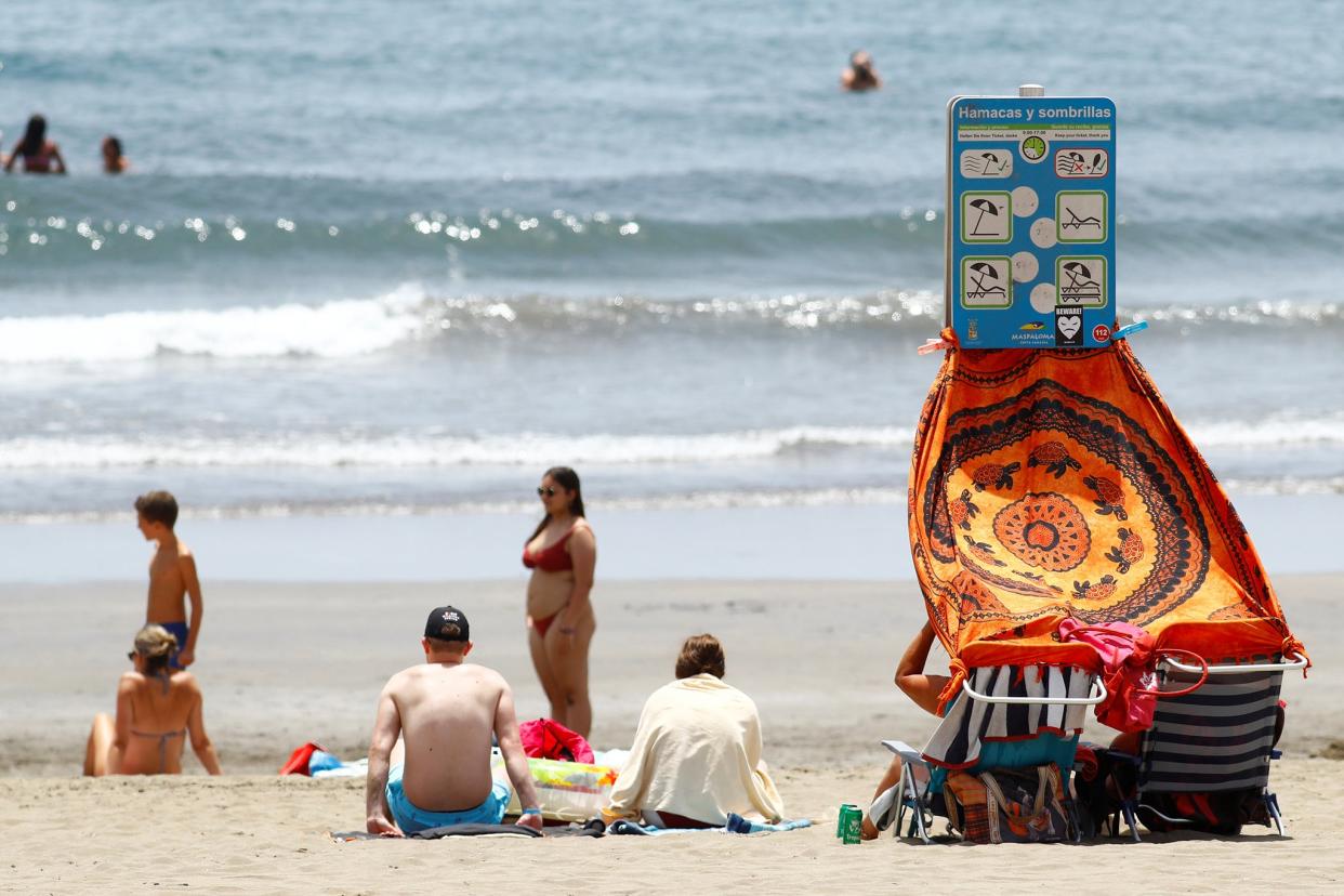 Tourists sit in Playa del Ingles in the south of the island of Gran Canaria, Spain (Reuters)