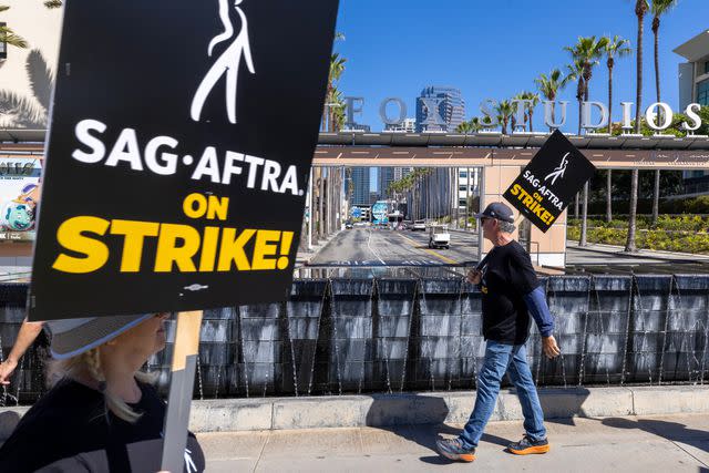 David McNew/Getty Striking SAG-AFTRA members walk a picket line in Los Angeles