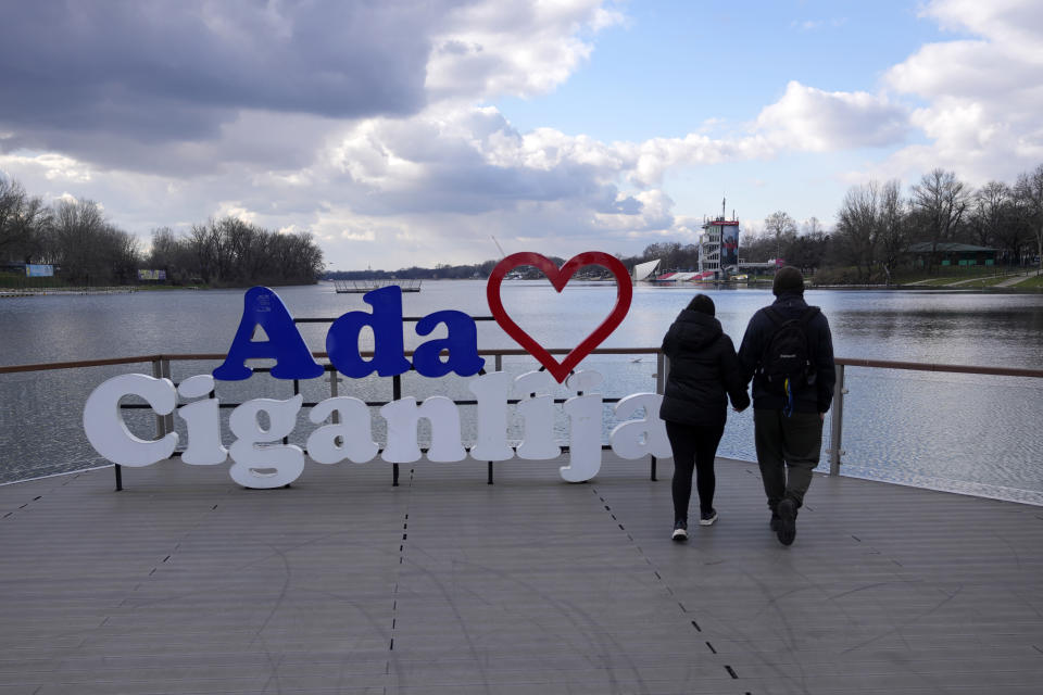Mariia Vyhivska, from Ukraine, left, and Iurii Kurochkin, from Russia, walk on the banks of the Ada Ciganlija Lake, in Belgrade, Serbia, Sunday, Feb. 5, 2023. Vyhivska and Kurochkin fell in love before Russia invaded Ukraine, while playing an online video game. To get together, they had to leave their homes and defy hatred generated by war. An estimated 200,000 Russians and some 20,000 Ukrainians have come to Serbia in the past year. (AP Photo/Darko Vojinovic)