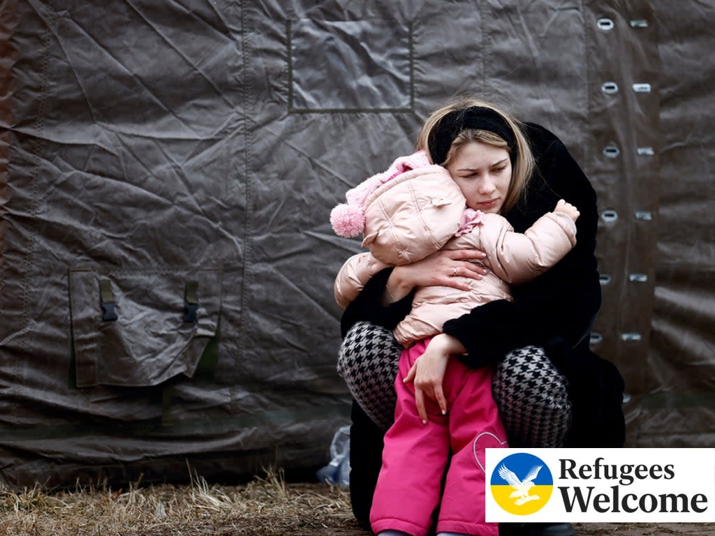 A woman fleeing Russian invasion of Ukraine hugs a child at a temporary camp in Przemysl, Poland, February 28, 2022.  (Reuters)