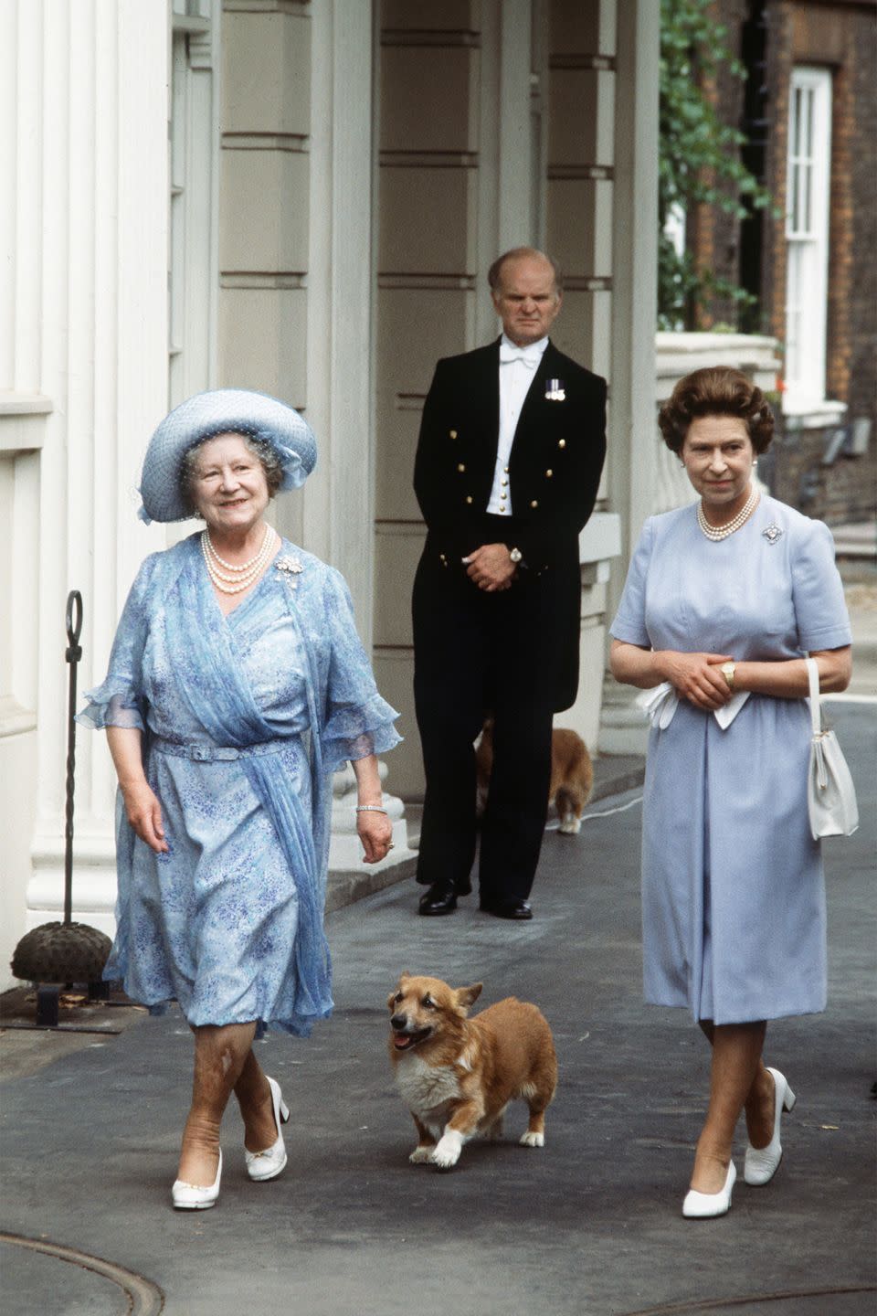 <p>The Queen Mother celebrated her 83rd birthday with her daughter Queen Elizabeth outside of Clarence House with her adorable corgi. The mother-daughter duo looked in-sync with their similar blue dresses and white heels.</p>