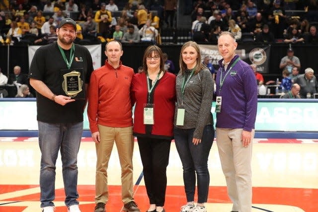 Legendary Shelby Daily Globe Sports Reporter Chuck Ridenour was posthumously inducted into the Ohio Prep Sportswriters Hall of Fame on Sunday during halftime of the Division II state boys basketball championship game. His son, Charlie Ridenour, wife, Pam, and daughter, Brooke Alt, accepted the award on his behalf presented by OPSWA Vice President Jake Furr and OHSAA Director of Media Relations.