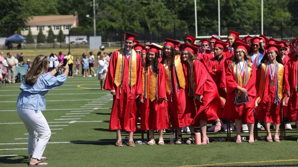 Graduates pose for a photo during Milford High School's graduation ceremony, June 12, 2022.