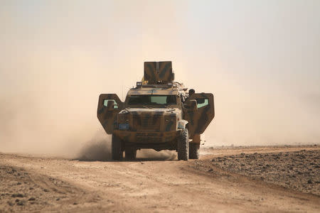 Syrian Democratic Forces fighters ride a military vehicle north of Raqqa city, Syria. REUTERS/Rodi Said