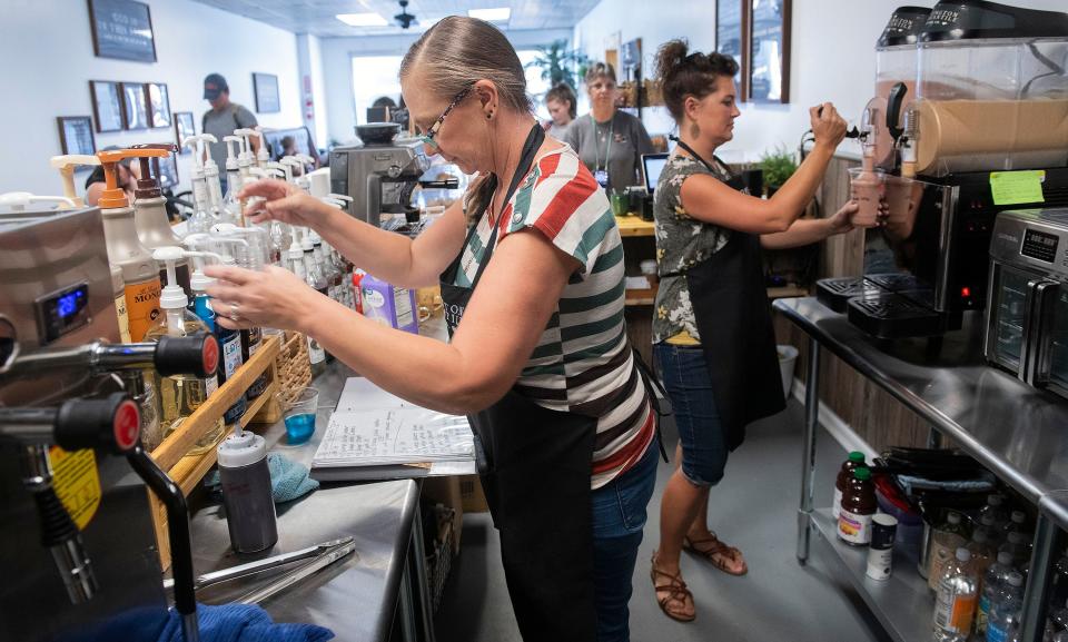 Baristas work to fulfill coffee orders to their customers at the new Covington Mercantile and Coffee Co. in Pea Ridge on Tuesday, July 18, 2023.