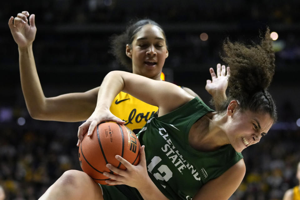 Cleveland State guard Sara Guerreiro (12) grabs a rebound in front of Iowa forward Hannah Stuelke during the first half of an NCAA college basketball game, Saturday, Dec. 16, 2023, in Des Moines, Iowa. (AP Photo/Charlie Neibergall)