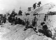 U.S. Army soldiers of the 8th Infantry Regiment, 4th Infantry Division, move out over the seawall on Utah Beach after coming ashore in front of a concrete wall near La Madeleine, France, on June 6, 1944. (Photo: U.S. National Archives/Army Signal Corps Collection/handout via Reuters)