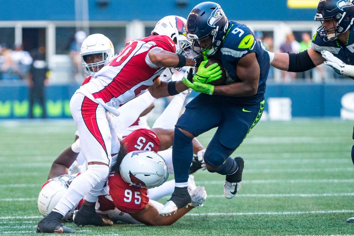 Seattle Seahawks running back Kenneth Walker III (9) breaks through a barrage of tackle attempts by Arizona Cardinals defenders during the third quarter of an NFL game on Sunday, Oct. 16, 2022, at Lumen Field in Seattle.