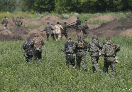 Pro-Russian separatist fighters from the so-called Battalion Vostok (East) walk towards a checkpoint in the eastern Ukrainian city of Donetsk, July 10, 2014. REUTERS/Maxim Zmeyev