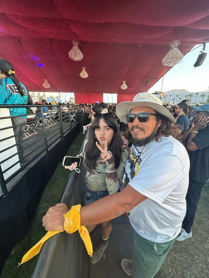Carlos Reckholder, Julieta Reckholder's husband, and their daughter wait for the next act at the Gobi tent during the 2023 Coachella Valley Music and Arts Festival  in Indio, Calif.