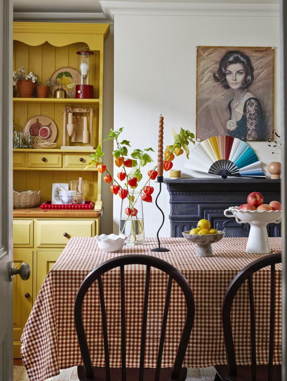 melanie lissacks dining table with a vase of flowers on it