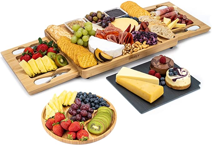 Product photo of wooden Cheese Board and Knife Set covered in fruit, crackers, and cheese