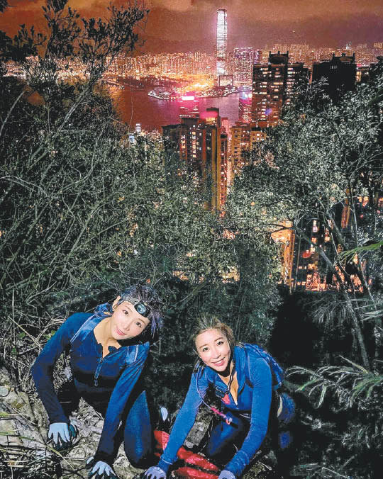 簡淑兒（左）和陳婉衡登頂後，身後的維港夜景盡收眼底。