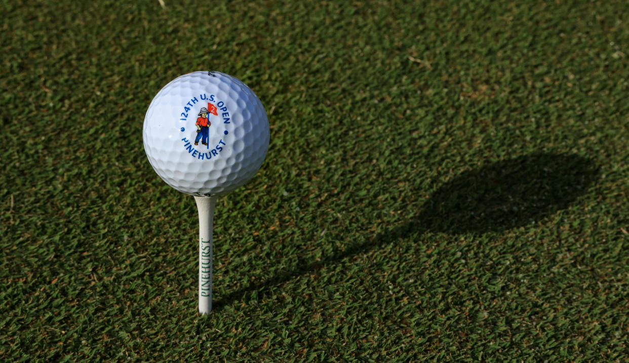  A golf ball on the tee that says Pinehurst No.2 US Open on it 