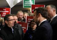 French President Emmanuel Macron talks with a member of the French farmers union FNSEA as he arrives at the 57th International Agriculture Fair (Salon international de l'Agriculture) at the Porte de Versailles exhibition center in Paris