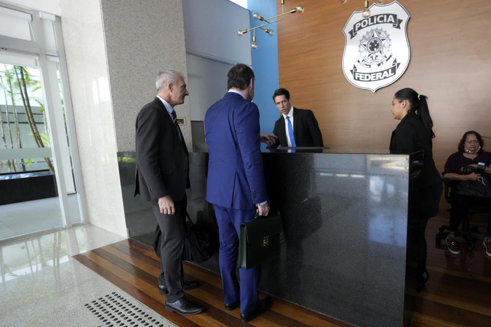 Lawyer Paulo Cunha, front right, accompanied by adviser Osmar Crivelatti, arrives to return weapons received by Brazil's former President Jair Bolsonaro at the Federal Police headquarters in Brasilia, Brazil, Friday, March 24, 2023. Representatives of Bolsonaro on Friday returned weapons he received from the United Arab Emirates and a set of jewels from Saudi Arabia, both of which he received during his presidency, as he was ordered to do by a Brazilian government watchdog. (AP Photo/Eraldo Peres)
