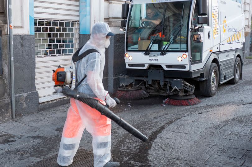 A cleaner cleaning pavements from the volcanic ash that fell during the volcano's paroxysmal phase on July 05, 2024 in Catania