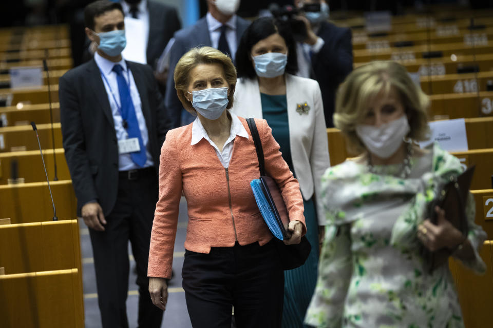 European Commission President Ursula von der Leyen, centre, wearing a face mask to protect against the spread of coronavirus, arrives to the main chamber before a plenary session at the European Parliament in Brussels, Wednesday, June 17, 2020. (AP Photo/Francisco Seco)