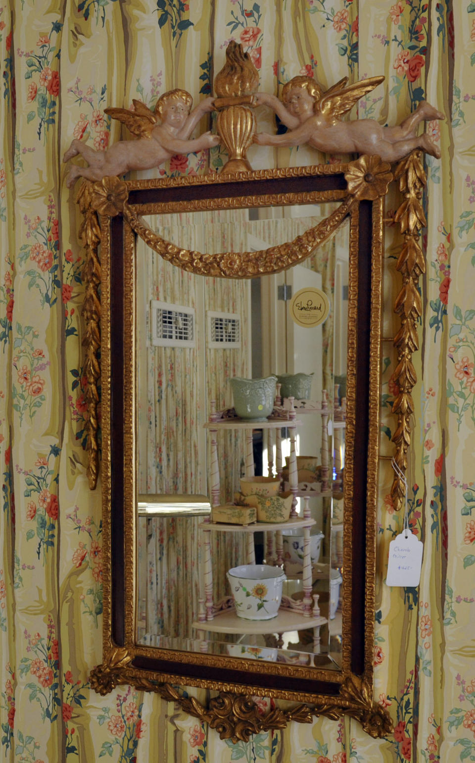 A Cherub Mirror, priced at $ 425.00, hangs on a wall at the home of the late crime novelist Elmore Leonard in Bloomfieeld Townships, Mich.,Thursday, March 6, 2014, the day of an estate sale on his belongings, Thursday, March 6, 2014. (AP Photo/The Detroit News, Charles V. Tines)