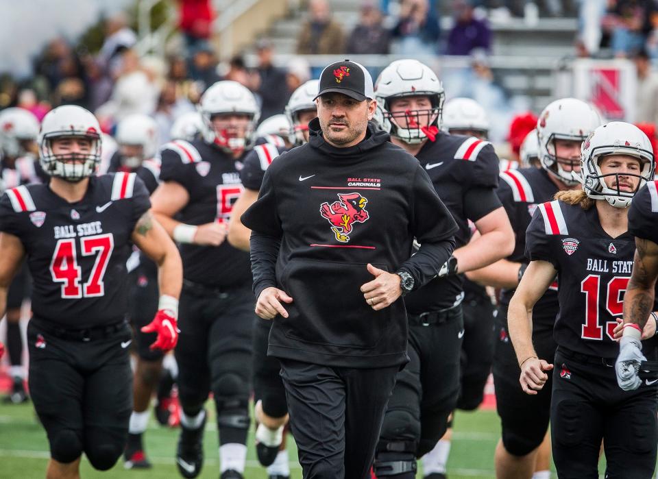 Ball State head coach Mike Neu leads his team onto the field prior to a Mid-American Conference game against Miami (Ohio) at Scheumann Stadium Saturday, Oct. 23, 2021. Miami defeated Ball State 24-17.