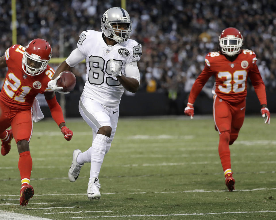 FILE - In this Oct. 19, 2017, file photo, Oakland Raiders wide receiver Amari Cooper (89) runs past Kansas City Chiefs cornerback Eric Murray (21) and defensive back Ron Parker (38) to score a touchdown during the first half of an NFL football game in Oakland, Calif. By moving Cooper around, the Raiders were finally able to get their star receiver going last week. (AP Photo/Marcio Jose Sanchez, File)