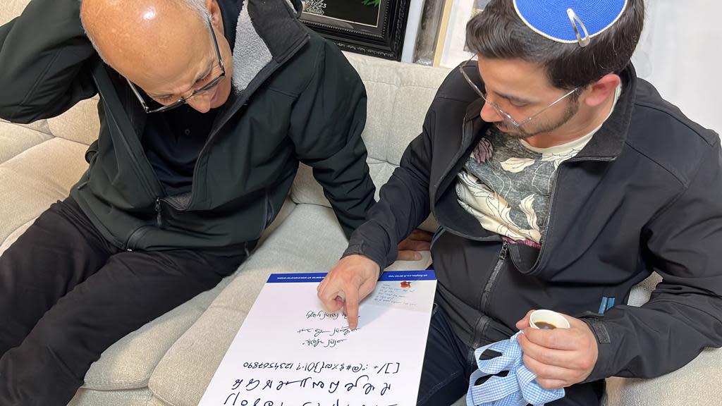 Graphic designer Elhanan Ben Uri presents a font created from the handwriting of Lt. Col. Salman Habaka to Habakas father, Imad, in January 2024.