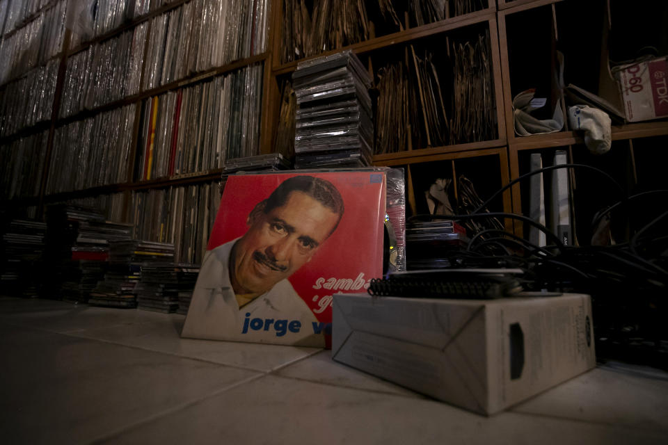 La portada del álbum "Samba E Ginga" de 1963 de Jorge Veiga apoyada contra un estante lleno de la colección de música de Carlos Savalla, en su estudio en Río de Janeiro, Brasil, el viernes 19 de abril de 2024. Savalla, un productor musical de 66 años en Río, Posee más de 60.000 discos de vinilo. (Foto AP/Bruna Prado)