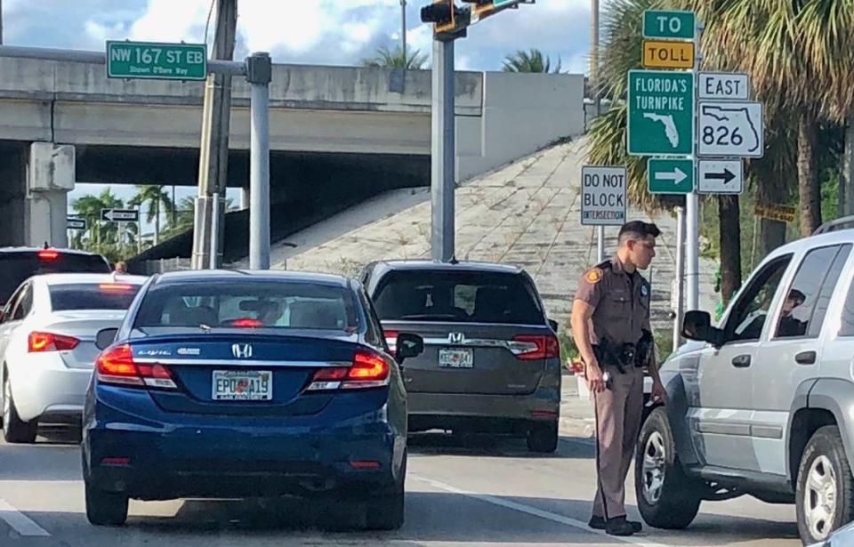 A Florida Highway Patrol officer speaks to a driver without wearing a mask in the Florida pandemic epicenter of Miami-Dade on Sunday, August 9, 2020. 