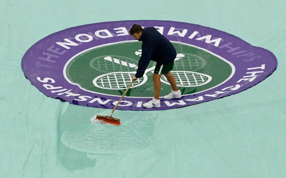 Ground staff cleans the covers on centre court during the second round match between Spain's Rafael Nadal and Lithuania's Ricardas Berankis - REUTERS/Toby Melville