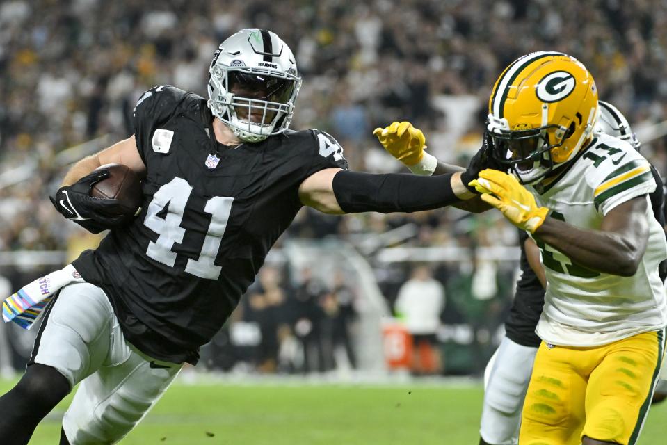 Las Vegas Raiders' Robert Spillane tries to get past Green Bay Packers' Jayden Reed after his interception during the first half of an NFL football game Monday, Oct. 9, 2023, in Las Vegas. (AP Photo/David Becker)