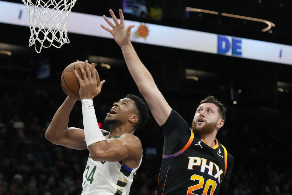 Milwaukee Bucks forward Giannis Antetokounmpo (34) has his shot stopped by Phoenix Suns center Jusuf Nurkic (20) during the first half of an NBA basketball game Tuesday, Feb. 6, 2024, in Phoenix. (AP Photo/Ross D. Franklin)