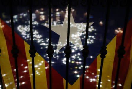 A ribbon formed by people with lights is seen through an Estelada flag during a demonstration called by pro-independence associations asking for the release of jailed Catalan activists and leaders at Sant Jaume square in Barcelona, Spain, November 16, 2017. REUTERS/Albert Gea