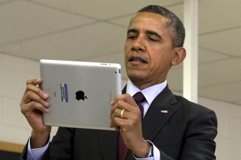 President Barack Obama looks at a classroom iPad in a seventh grade classroom before speaking about his ConnetED goal of connecting 99% of students to next generation broadband and wireless technology within five years, Tuesday, Feb. 4, 2014, at Buck Lodge Middle School in Adelphi, Md. (AP Photo/Jacquelyn Martin)