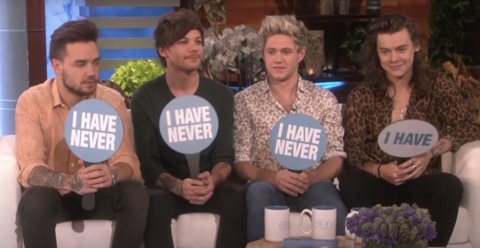 The members of One Direction hold signs to indicate their answers; Harry's says "I have" while all the other say "I have never"