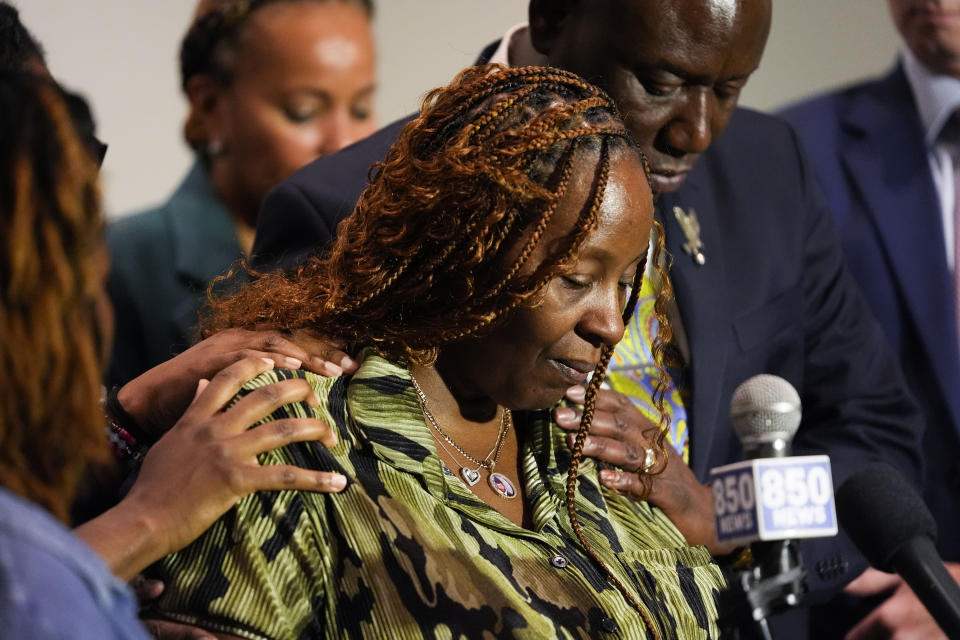 CORRECTS SERVICE BRANCH TO U.S. AIR FORCE INSTEAD OF U.S. NAVY - Chantemekki Fortson, mother of Roger Fortson, a U.S. Air Force senior airman, is comforted as she speaks about her son during a news conference regarding his death, with attorney Ben Crump, behind, Thursday, May 9, 2024, in Fort Walton Beach, Fla. Fortson was shot and killed by police in his apartment, May 3, 2024. (AP Photo/Gerald Herbert)