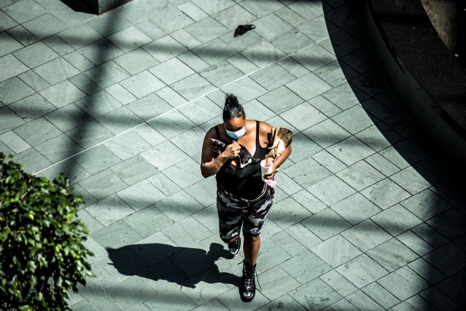 A shopper wearing a facemask carries a dog through the Mall of America on June 16, 2020 in Bloomington, Minnesota, after some of the shops at the mall reopened on June 10. (Photo: KEREM YUCEL/AFP via Getty Images)