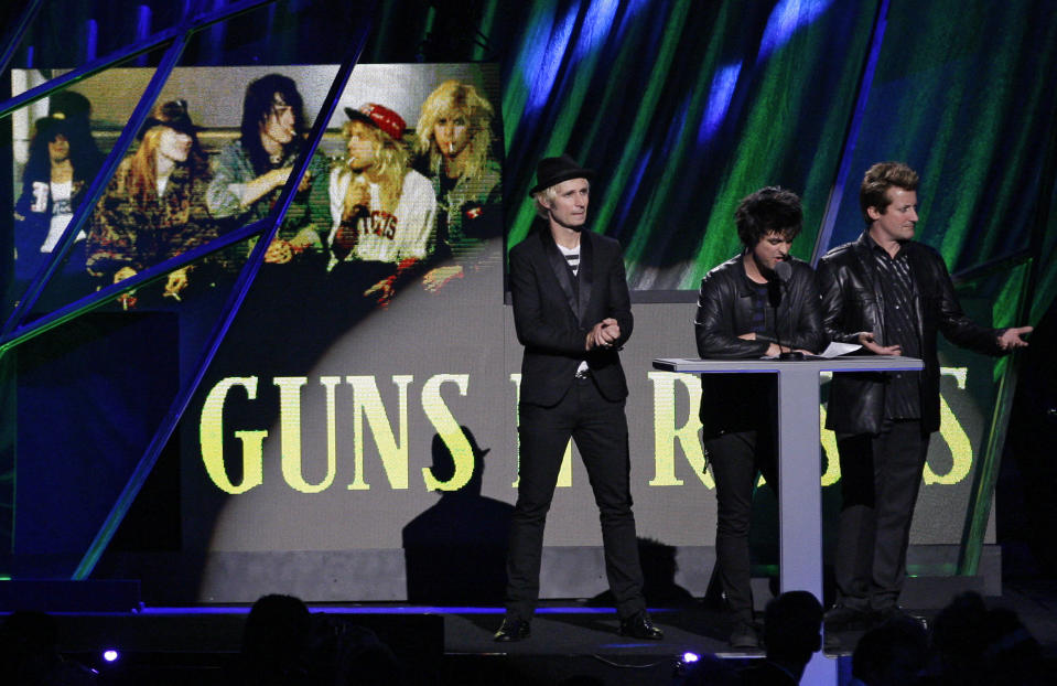 Green Day's Tre Cool, right, Billy Joe Armstrong, second from right, and Mike Dirnt introduce Guns N' Roses for induction into the Rock and Roll Hall of Fame Saturday, April 14, 2012, in Cleveland. (AP Photo/Tony Dejak)