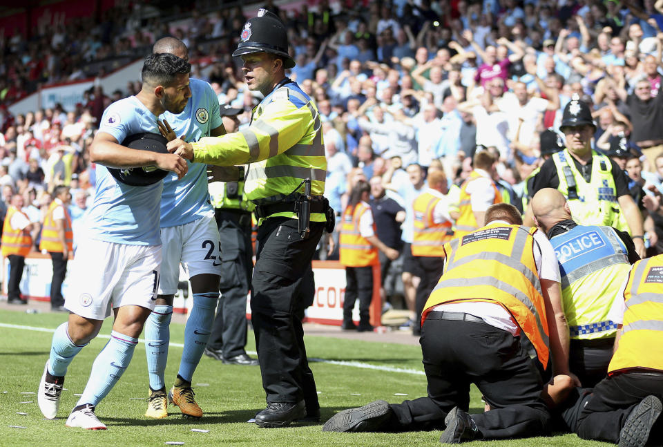 Manchester City’s Sergio Aguero is held back by police after Raheem Sterling’s winner and the ensuing celebrations. (Steve Paston/PA via AP)