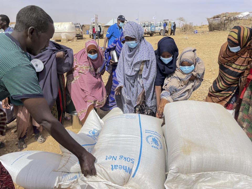 Food supplies of wheat are distributed during a visit by World Food Programme (WFP) Regional Director Michael Dunford to a camp for the internally-displaced in Adadle, in the Somali Region of Ethiopia Saturday, Jan. 22, 2022. Drought conditions have left an estimated 13 million people facing severe hunger in the Horn of Africa, according to the United Nations World Food Program. (Claire Nevill/WFP via AP)