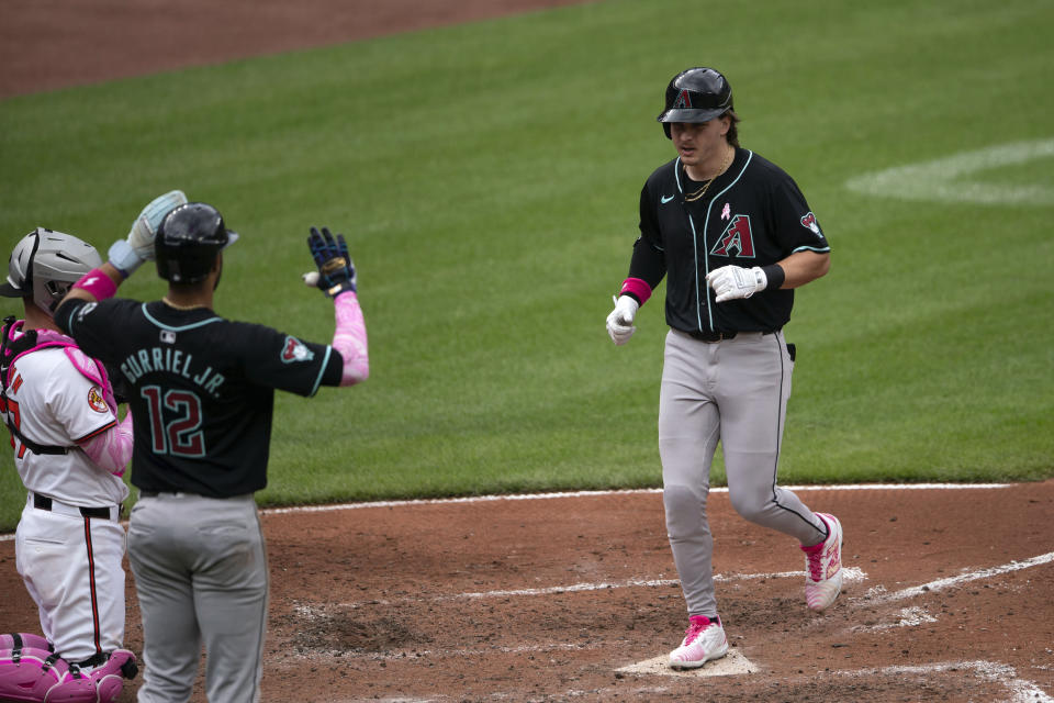 Arizona Diamondbacks' Jake McCarthy, right, scores during a baseball game against the Baltimore Orioles, Sunday, May 12, 2024, in Baltimore. (AP Photo/Jose Luis Magana)